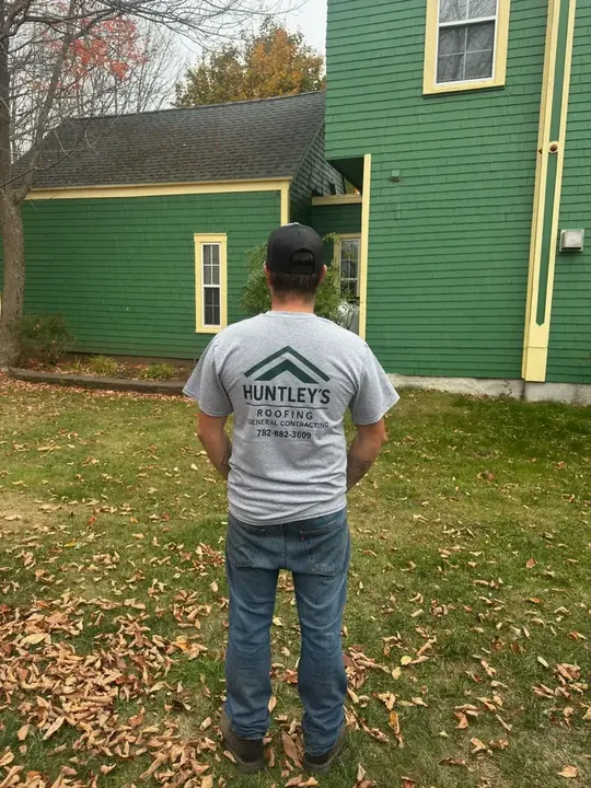 Zackory Huntley wearing a Huntley&rsquo;s Roofing branded t-shirt at a worksite in autumn.