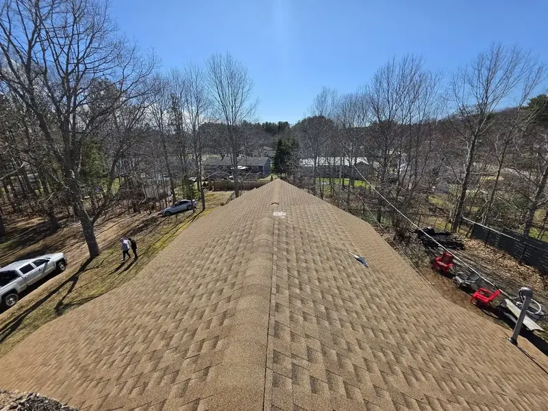 Finished new shingle roof on a residential home with chimney.
